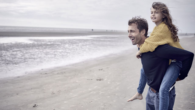 man and daughter on beach