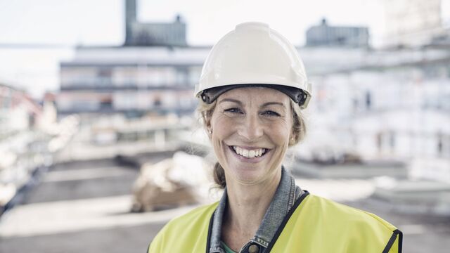 Frontpage - Happy female architect at construction site SMALL