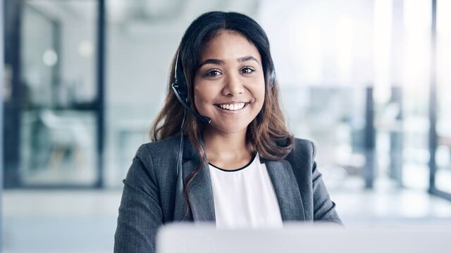Front page - Young woman using a headset and laptop Small